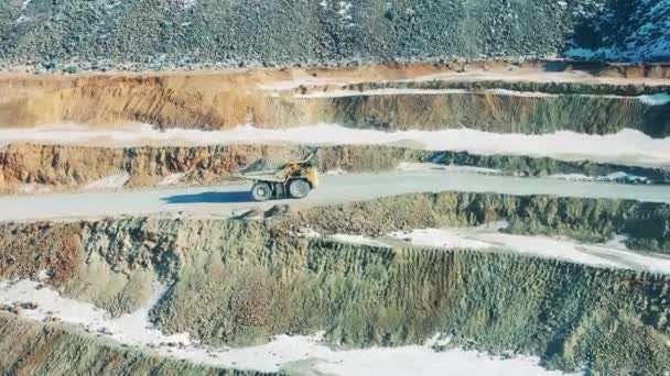 Snowy road of an open-cut mine with a truck riding along — Stock video
