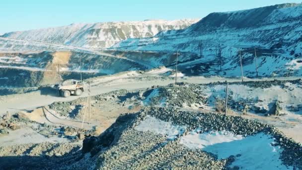 Snowy quarry with a truck transporting ore — Stock Video