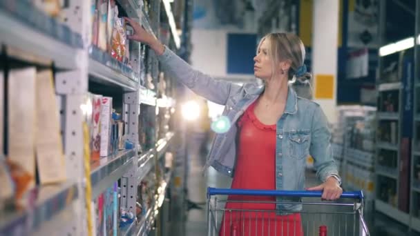 Uma mulher está escolhendo cereais enquanto faz compras — Vídeo de Stock