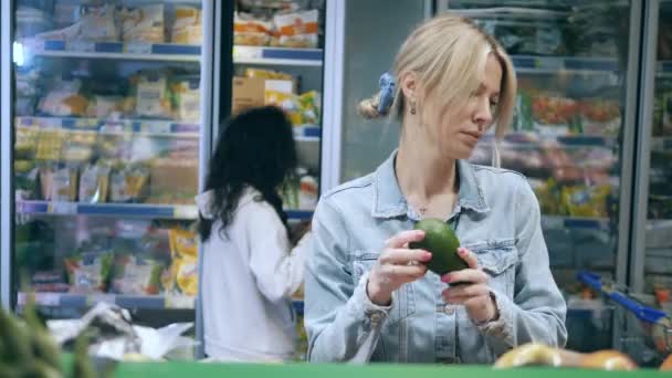 A nők gyümölcsöt és fagyasztott ételt vásárolnak a boltban. — Stock videók