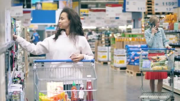 Supermarkt gangpad met mensen die dingen kiezen om te kopen — Stockvideo