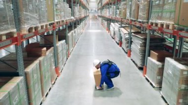 Dış iskelet, dış giysi, robot teknolojisi konsepti. Erkek işçi depodan bir kutu alıyor.