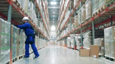 Kutular bir depo işçisi tarafından birleştiriliyor. Dış iskelet, dış giysi, robotik endüstriyel teknoloji konsepti.