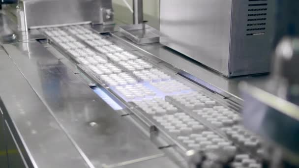 Droga, attrezzatura per fabbriche di farmaci. Le capsule di farmaco in blister si muovono lungo il trasportatore — Video Stock