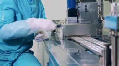 Eczacı taşıyıcıdaki kapsül haplarını değiştiriyor.