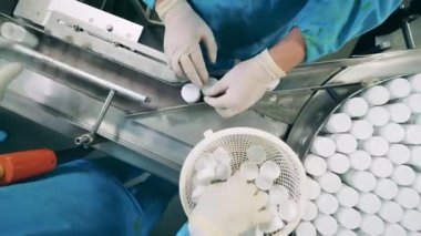 Farmakologlar ilaç dolu tüpleri taşıyıcıdan geçiriyorlar.