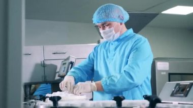 Erkek farmakolog, ilaç tüplerini elle kapatıyor.