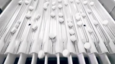 Adımlı taşıyıcı beyaz hapların yerini değiştiriyor.