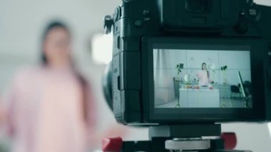 Genç bir bayanın yemek pişirirken çekilmiş bir video görüntüsü.