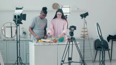 Birlikte yemek pişiren iki gencin video çekimi.