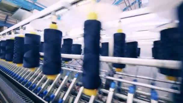 Bobinas con hilos azules unidas a máquinas de coser de fábrica — Vídeos de Stock