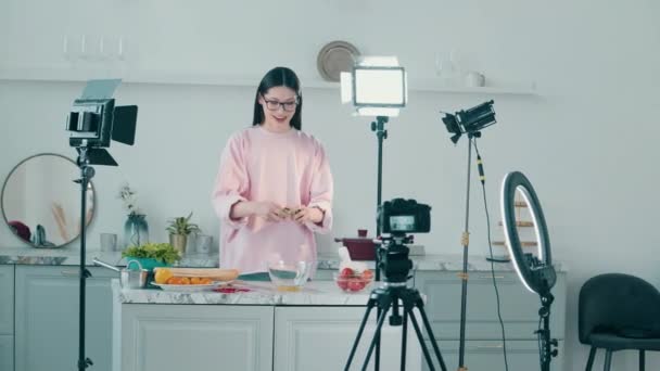Genç bayan bir vlog için yemek pişirirken gülümsüyor — Stok video
