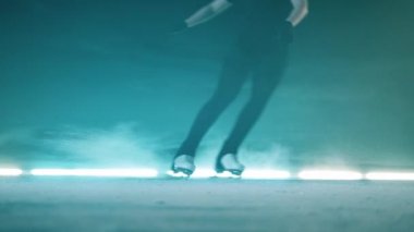 Buz pateni pistinde yüzey boyunca kayan bir sporcu.