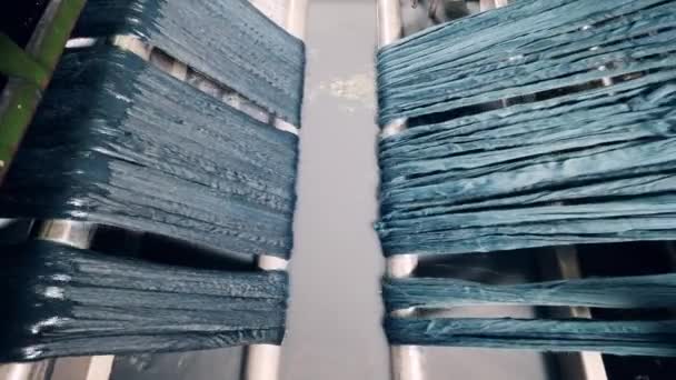 Yarn strings are getting run through a rolling mechanism — Stock Video