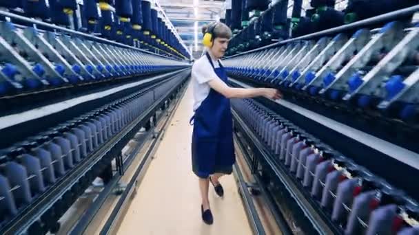 Especialista feminina está à procura de fios defeituosos nas máquinas de costura — Vídeo de Stock