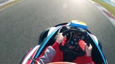 Sürücü pistte bir yarış arabası sürüyor.