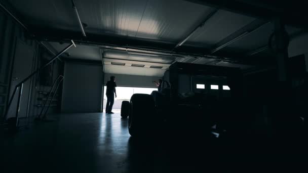 Two men are opening a garage with a racing car in it — Stock Video