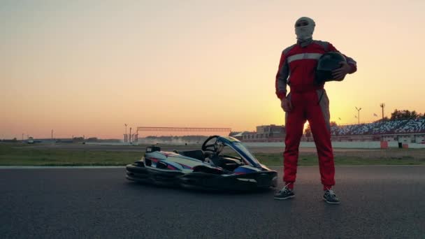 A racer is standing next to a car and puts a helmet on — Stock Video