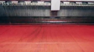 İplikler dokuma makinesi tarafından kumaş yapımında kullanılıyor.