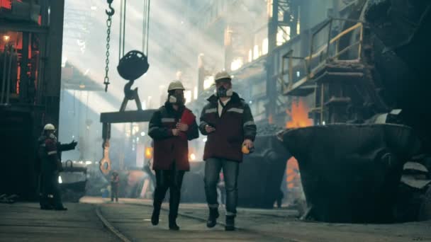 Staalfabriek collega 's in veiligheidskleding lopen langs de fabriek — Stockvideo