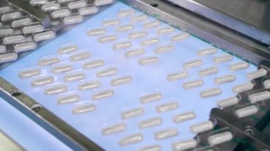 Taşıyıcı bant, kabarcıklardaki kapsül haplarının yerini değiştiriyor.