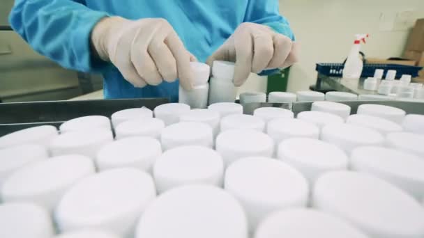 Pill tubs worden verplaatst naar de transportband — Stockvideo