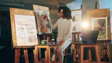 Afro-Amerikan öğretmen resim yapmayı video dersi ile açıklıyor.