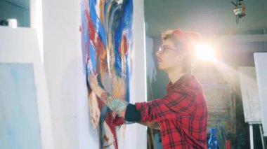 Erkek sanatçı elleriyle resim çizerken yağlı boya kullanıyor.