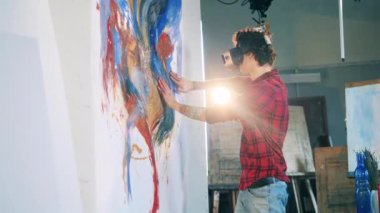 Ressam çıplak elle çizerken VR gözlük takıyor.