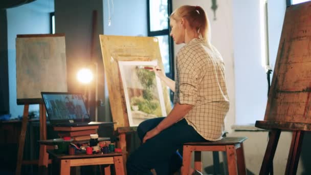 Rubia dama está aprendiendo a pintar a través de vídeo lección — Vídeos de Stock