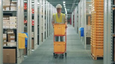 Erkek çalışan depolama konteynırları taşıyor.