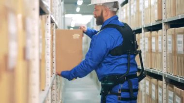 Ergoskeleton 'daki depo işçisi raftan bir kutu alıyor.