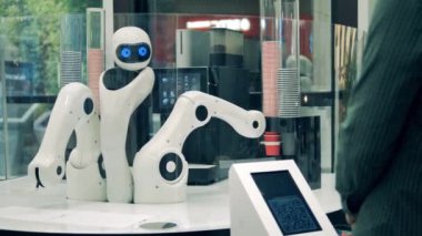 Yenilik, modern teknoloji konsepti. Bir müşteriye kahve dükkanında droid servis ediliyor.
