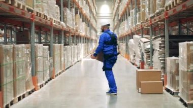 Erkek çalışan, kutuları taşırken ergoskeleton giyiyor.