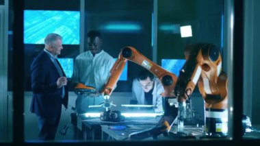 Erkek bilim adamları robotlarla deney yaparken konuşuyor.