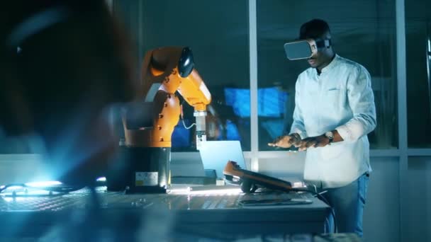 Африканский ученый в виртуальных очках управляет роботизированной рукой — стоковое видео