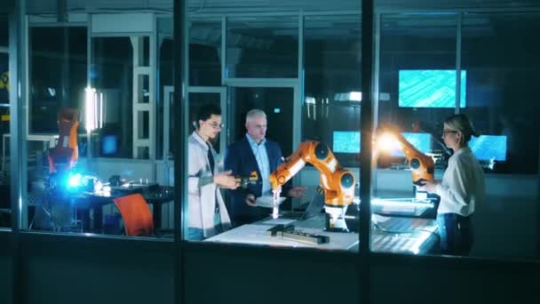 Laboratuvarda robotlarla birlikte bir grup bilim adamı var. — Stok video