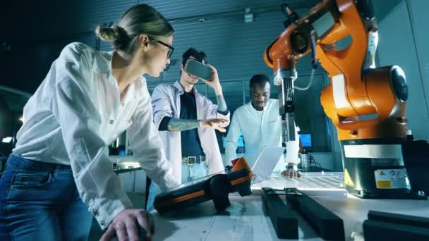 Los investigadores están operando un brazo robótico en realidad virtual. Ingenieros profesionales que trabajan en un moderno laboratorio industrial. — Vídeo de stock