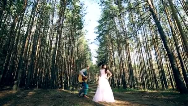 Atractiva pareja divirtiéndose juntos, bailando, tocando la guitarra, firmando, bromeando . — Vídeo de stock