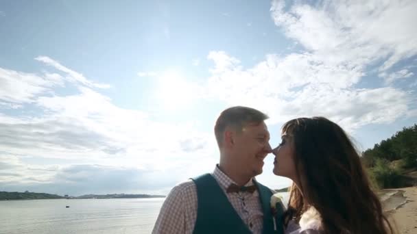 Man and woman, young happy married couple silhoutte kissing on the shore. — Stock Video