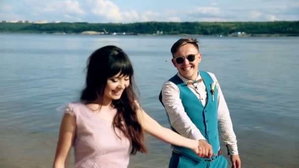 Мужчина и женщина, молодые люди, счастливая супружеская пара, развлекающаяся и играющая на берегу, на пляже . — стоковое видео