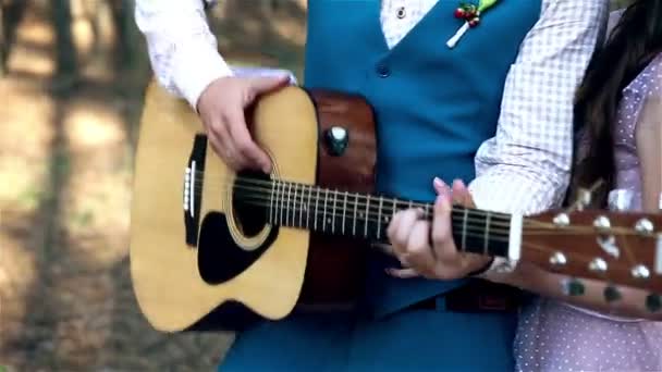 Atractiva pareja divirtiéndose juntos, bailando, tocando la guitarra, firmando, bromeando . — Vídeo de stock