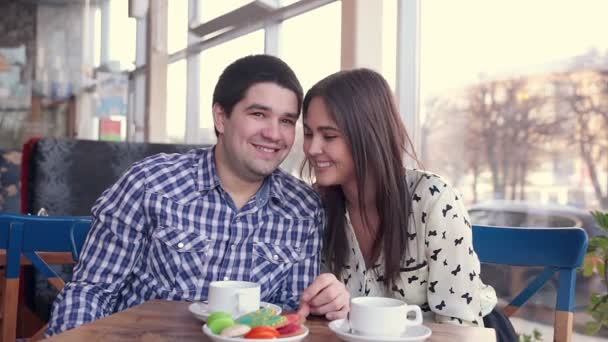 Feliz pareja amorosa en la cafetería riendo, bebiendo té. usando la tableta para la diversión. Primera cita . — Vídeo de stock