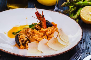 Deniz mahsullü risotto ve beyaz tabakta parmesan peyniri..