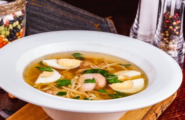 Erişteli tavuk çorbası ve beyaz tabakta yumurta.