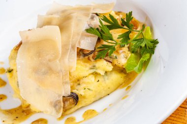 Beyaz tabakta patates püresi ve peynir.