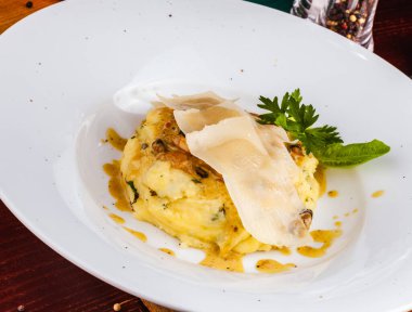 Beyaz tabakta patates püresi ve peynir.