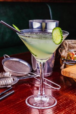 Ahşap masada salatalık martini kokteyli.