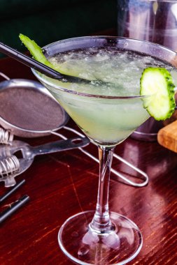 Ahşap masada salatalık martini kokteyli.