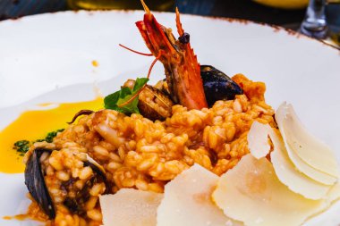 Deniz mahsullü risotto ve beyaz tabakta parmesan peyniri..